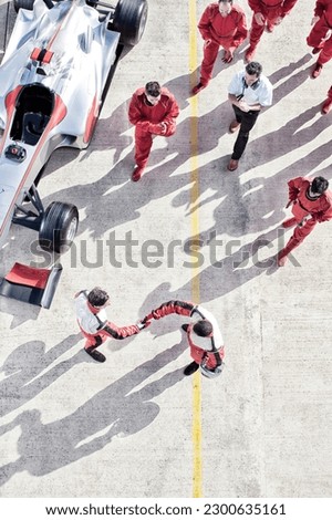 Racers shaking hands on track Royalty-Free Stock Photo #2300635161