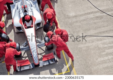 Racing team working at pit stop Royalty-Free Stock Photo #2300635175