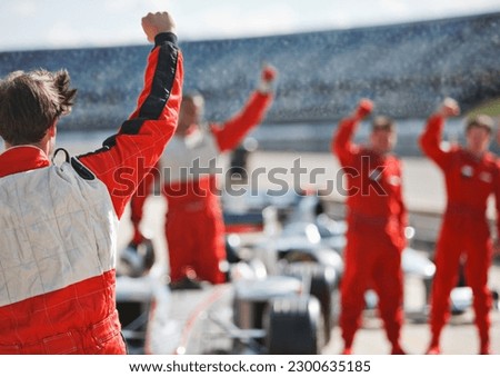 Racer and team cheering on track Royalty-Free Stock Photo #2300635185