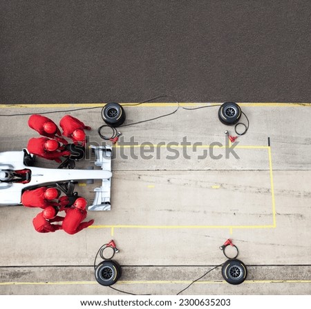 Racing team working at pit stop Royalty-Free Stock Photo #2300635203
