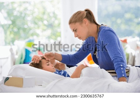 Mother feeling sick son's forehead Royalty-Free Stock Photo #2300635767