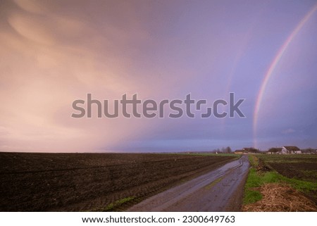 Vibrant Double Rainbow Against a Stormy Backdrop