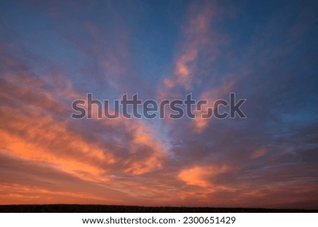 The colors in the sky transition from warm oranges to cool blues, creating a beautiful blend of hues Royalty-Free Stock Photo #2300651429