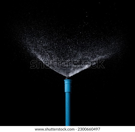 Sprinkler watering isolated on black background Royalty-Free Stock Photo #2300660497