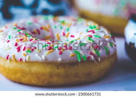 Close-up on ring donut with white glaze and colourful hundreds and thousands