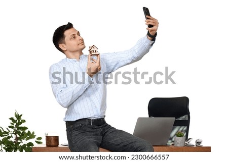 caucasian businessman holding toy house in the office