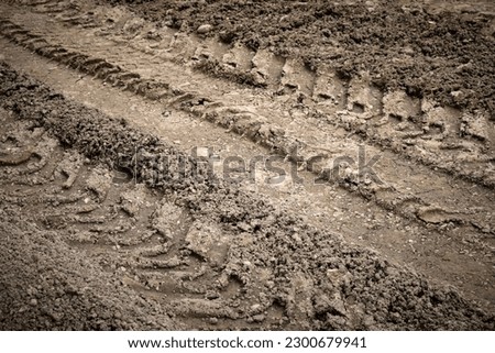 Close-up of the imprint of the tire tread of the wheel of a heavy construction equipment or truck. Royalty-Free Stock Photo #2300679941