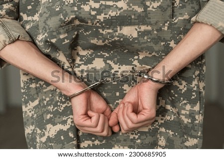 Handcuffed soldier in military army clothes. Close up of hands in handcuffs Royalty-Free Stock Photo #2300685905