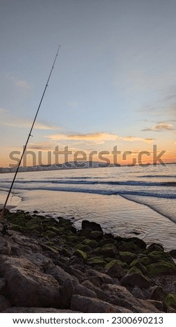picture of Mediterranean sea waves at sunset in Tangier, Morocco.  People fishing in the sea.
