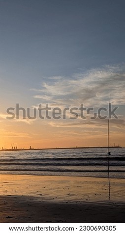 picture of Mediterranean sea waves at sunset in Tangier, Morocco.  People fishing in the sea.