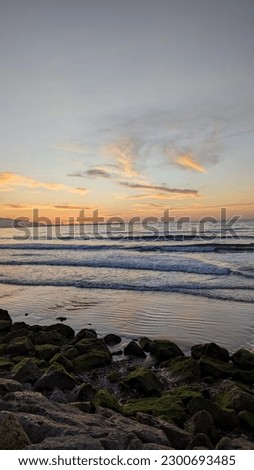 picture of Mediterranean sea waves at sunset in Tangier, Morocco.  People exercising in the sand.