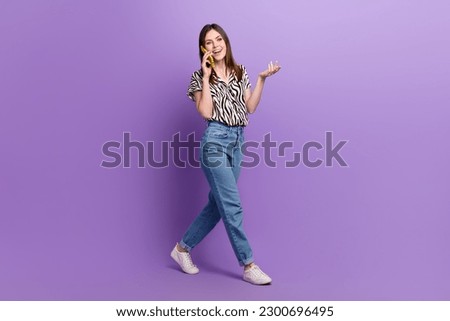 Full body portrait of positive nice lady walking speak communicate telephone isolated on purple color background