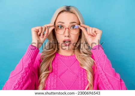 Photo of sweet shocked lady wear pink sweater arms spectacles big eyes isolated blue color background