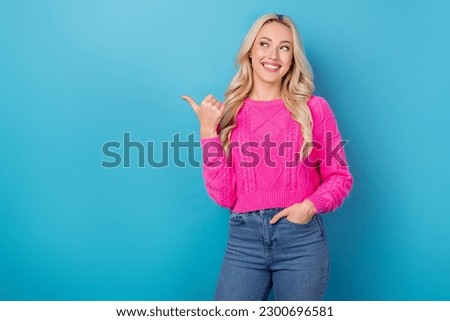 Photo of dreamy adorable lady wear pink sweater looking pointing thumb empty space isolated blue color background