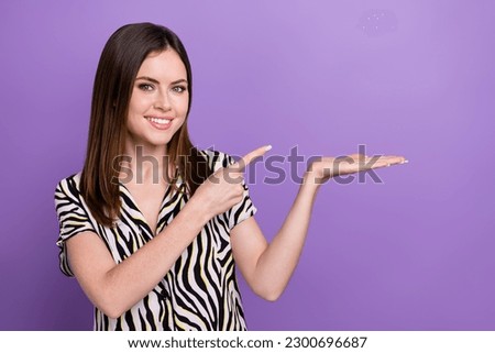 Photo of young woman wear zebra print shirt hold hand point finger product empty space best free website isolated on purple color background