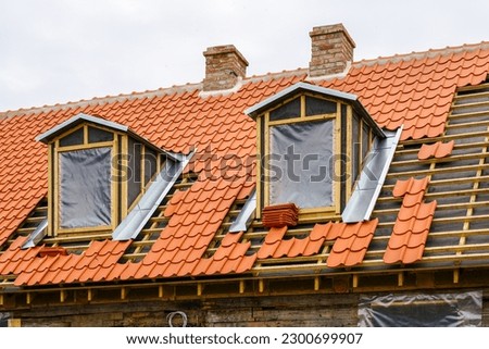 Restoration of roof wooden structures and clay tiles roofing replacement of historic house Royalty-Free Stock Photo #2300699907