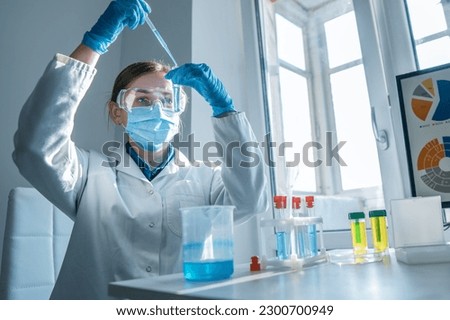 Scientist, chemist conducting an experiment on the synthesis of a new pharmaceutical drug in the laboratory. Research in a medical laboratory to identify new ways to diagnose and treat cancer. Royalty-Free Stock Photo #2300700949