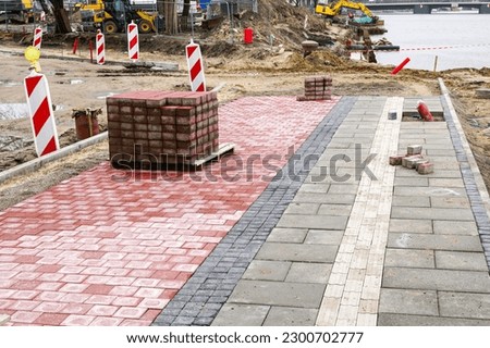 Paving of a new wide sidewalk with a bicycle path and guidelines for the visually impaired, tactile paving