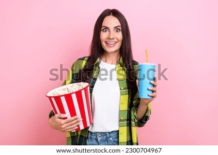 Photo of impressed girl straight hairstyle checkered shirt hold popcorn drink watch excited movie isolated on pink color background