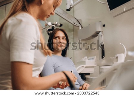Portrait of friendly female doctor and patient at dentist's office.