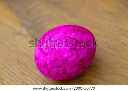 A pink painted egg is on the table. Preparing for Easter
