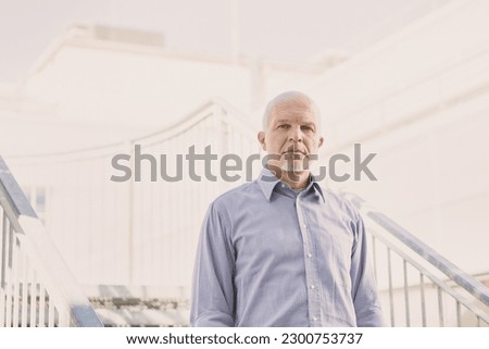 Senior pensive outside the company. He walks this stairway every day and solves old and new problems every day. Challenges for him are the norm and so winning them. Royalty-Free Stock Photo #2300753737