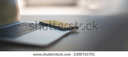 Smartphone on laptop on desk, work from home concept