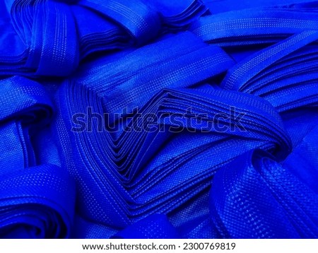 stacks of blue non-woven fabric tote bags. collections made of non-woven fabrics. textured and porous polypropylene bags.  Royalty-Free Stock Photo #2300769819