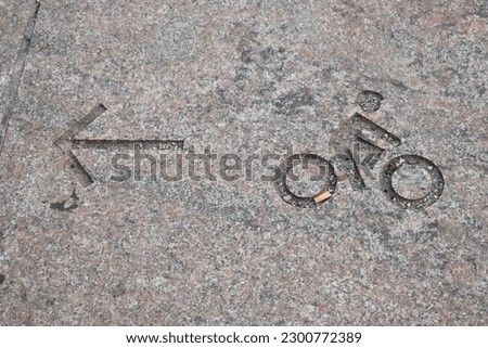 Bike Symbol on Sidewalk with Arrow Pointing Left
