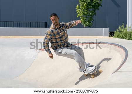 Surf skater performing a turn on a skatepark during a sunny day. Royalty-Free Stock Photo #2300789095