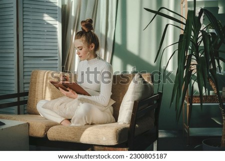Young attractive woman writing with pencil in her journal in morning time on weekend. Leisure and recreation concept. For lifestyle design. Happy lifestyle Royalty-Free Stock Photo #2300805187