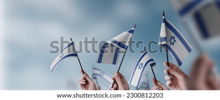 A group of people holding small flags of the Israel in their hands. Royalty-Free Stock Photo #2300812203