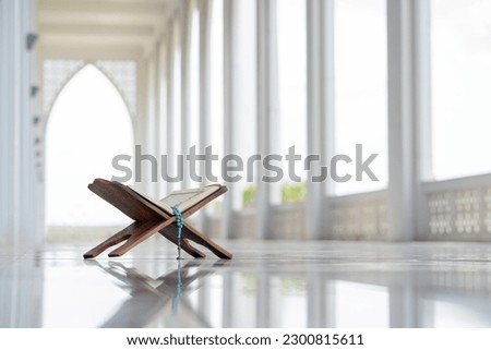 Islamic concept - The Holy Al Quran with written Arabic calligraphy meaning of Al Quran and rosary beads or tasbih, Arabic word translation: The Holy Al Quran (holy book of Muslim)  Royalty-Free Stock Photo #2300815611