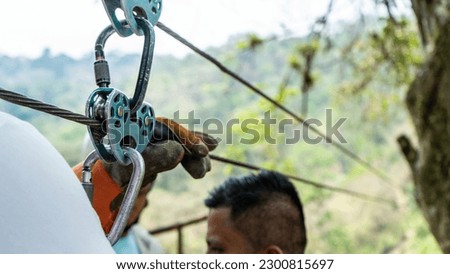 Tourist preparing harnesses to launch for a canopy in front of a waterfall in Matagalpa, Nicaragua, Centroamerica Royalty-Free Stock Photo #2300815697