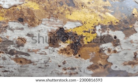 High-resolution Stock Photos of a metal Surface with a worn yellow paint texture that's been rusted over time creating a unique and rustic texture perfect for backgrounds, textures, Industrial design.