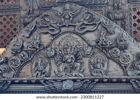 Decorative religious wood carving at a Hindu Kedareshwor temple in Pokhara, Nepal. Many-armed and many-headed Shiva surrounded by Nagas and demigods. Royalty-Free Stock Photo #2300851227