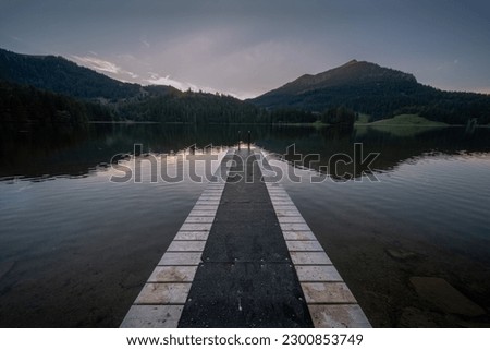 A Wooden Ramp into The Silent Lake with Dark Sunset Background