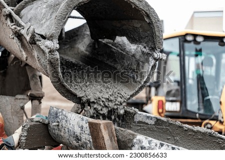 Mixer truck is transport concrete to the casting place on building site, Selective focus. Concrete is flowing into the foundations of the building. Monolithic concrete works Royalty-Free Stock Photo #2300856633