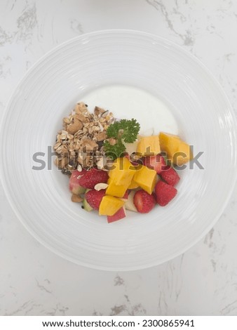 Greek yogurt with fresh fruit hole grain and honey in bowl, stock photo