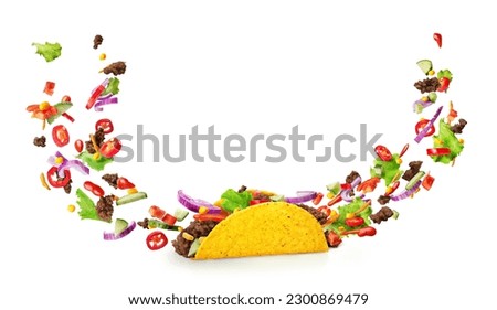 Sliced filling flying out from both sides of a Mexican taco in the form of a smile, isolated on a white background