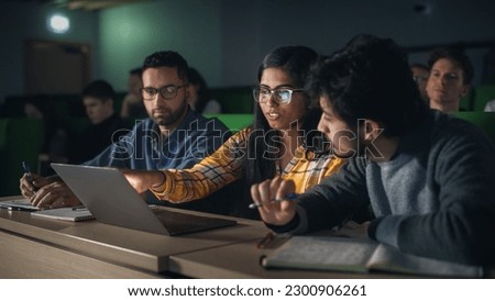 Group of Multiethnic Enthusiastic Students Collaborate in University Classroom, Compare Research Project Findings on a Laptop Computer. Diverse Scholars Working as a Team on College Homework Royalty-Free Stock Photo #2300906261