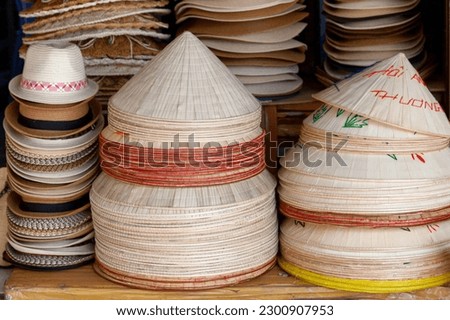 Straw hats for sale on the stalls of a shophouse in Hoi An, Vietnam.