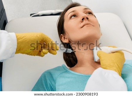 Fine needle aspiration biopsy of thyroid gland for woman patient guided of doctor with ultrasound machine. Thyroid biopsy Royalty-Free Stock Photo #2300908193