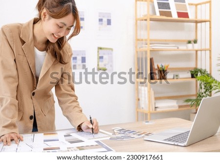Portrait of Cheerful young asian female architect working on project. Interior designer in office working on a project.