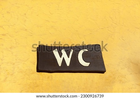 WC sign inscription .  Signboard toilet inscription 