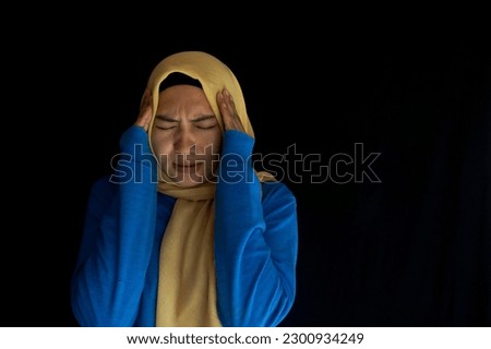 Beautiful young Asian woman looking dizzy and having headache on black background. Medical healthcare concept