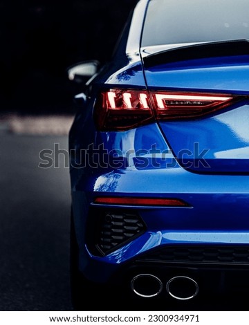A back view of a shiny blue sport car lights with blur background, vertical shot Royalty-Free Stock Photo #2300934971