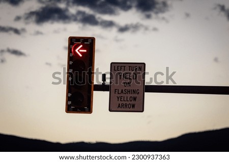 A closeup shot of a traffic light and sign indicating "left turn yield on flashing yellow arrow"