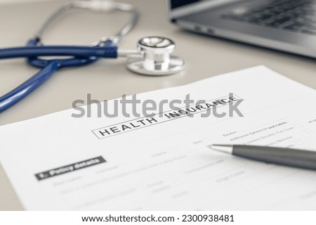 Health Insurance form, pen and stethoscope on doctor desk