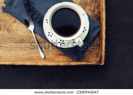 Cup of coffee on old wooden tray background .